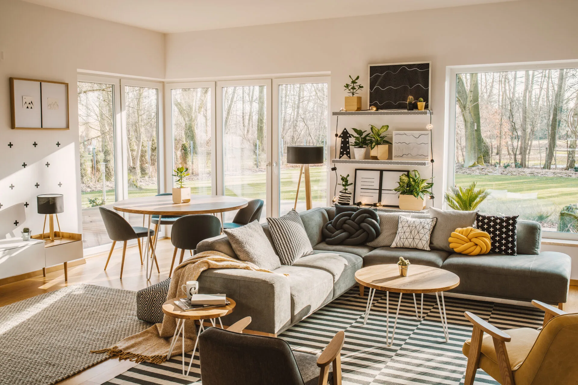 A bright couch with a kitchen table in a brightly lit living area 