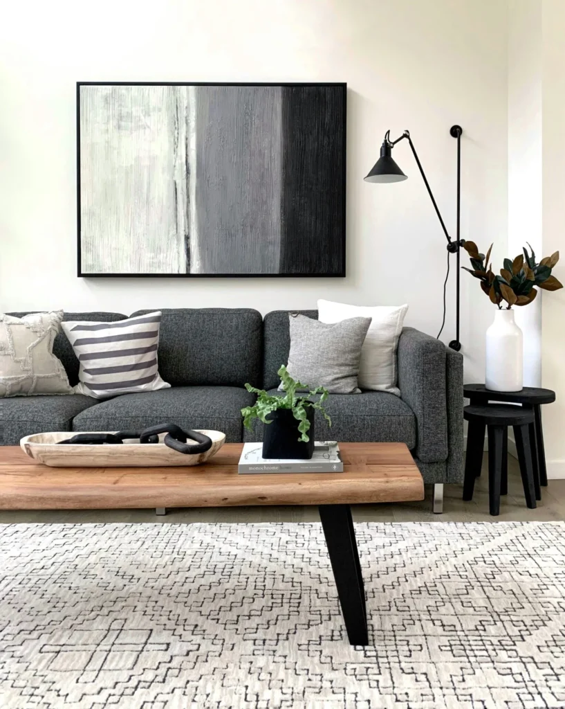 A bright sitting room with a large couch, artwork a coffee table and lamp