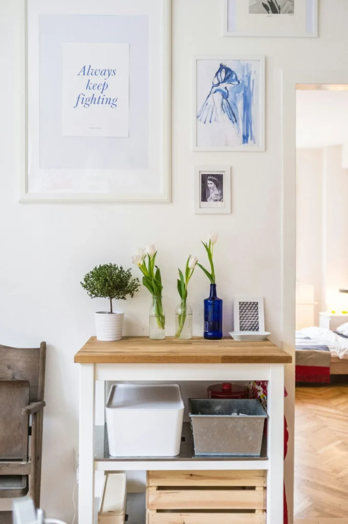 A room in a bright house with a table, assorted plants and artwork